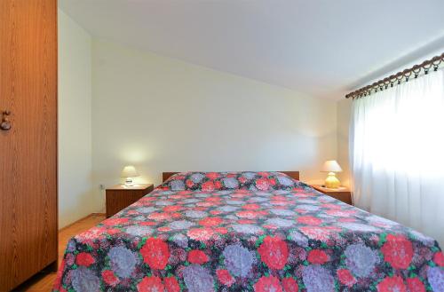 sypialnia z łóżkiem z kolorową kołdrą w obiekcie Apartments with a parking space Fazana - 19641 w Fažanie