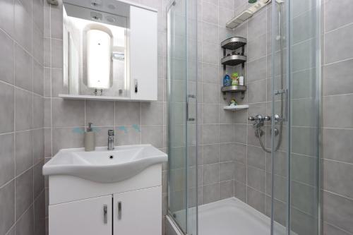een badkamer met een wastafel en een douche bij Apartments by the sea Palit, Rab - 19661 in Rab