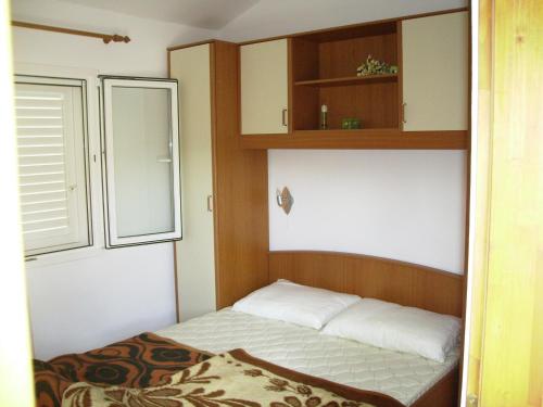 a small bedroom with a bed and a window at Apartments by the sea Basina, Hvar - 19668 in Vrbanj