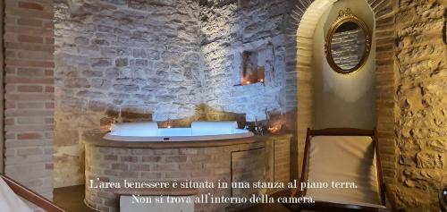 baño con lavabo en una pared de piedra en La Luna nel Borgo, en Spello