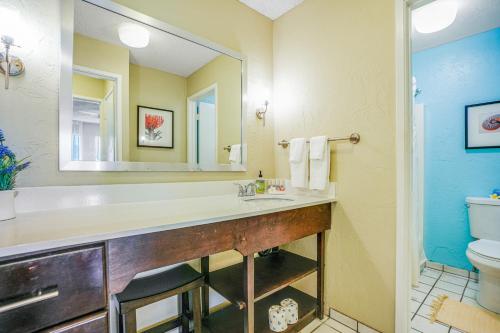 a bathroom with a sink and a toilet and a mirror at Plantation Hale D10 in Kapaa