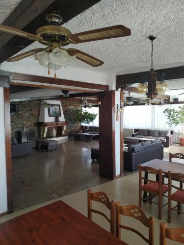 a living room with a ceiling fan and a table at Daskalio Beach Hotel in Keratea
