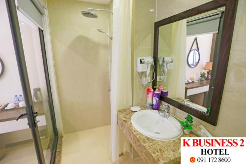 a bathroom with a sink and a shower and a mirror at K Business 2 Hotel My Dinh 미딩 in Hanoi