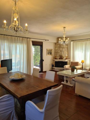 a living room with a table and chairs and a fireplace at Daphne Villas in Kriopigi