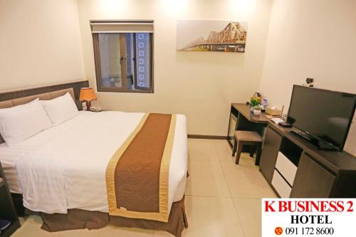 Dormitorio con cama, escritorio y TV en K Business 2 Hotel My Dinh 미딩, en Hanói