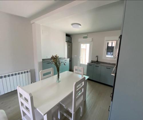 a dining room with a white table and chairs at Apartamento turístico La Torre in Santacara