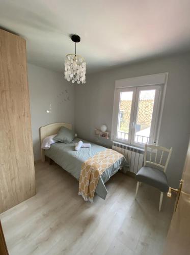 a bedroom with a bed and a chair and a chandelier at Apartamento turístico La Torre in Santacara