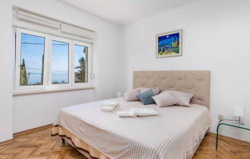 a white bedroom with a large bed with two towels on it at Vallelosca Garden in Opatija