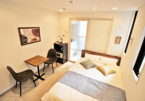 a bedroom with a bed and a table and chairs at Apartment Hotel Hakata in Fukuoka