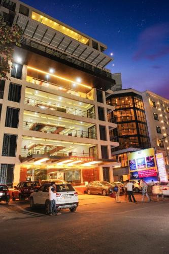 a large building with cars parked in front of it at Hotel Radiant Kolhapur in Kolhapur