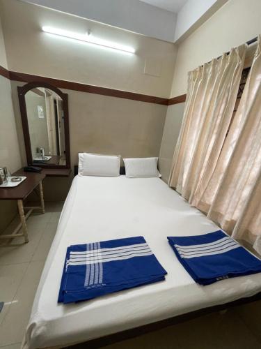 a bedroom with a bed with blue and white towels on it at Golden Guest House in Bangalore
