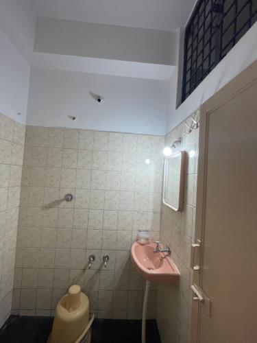 ein Badezimmer mit einem rosa Waschbecken und einem WC in der Unterkunft Golden Guest House in Bangalore