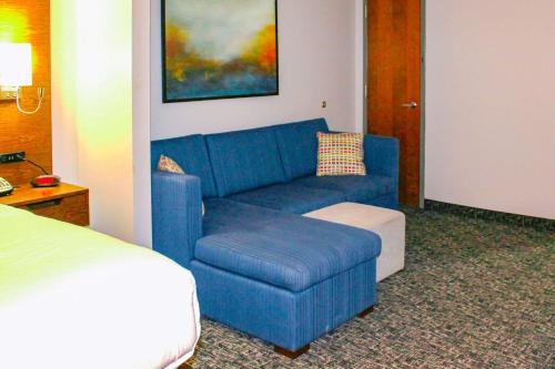 a blue couch and a chair in a hotel room at Comfort Inn & Suites Near Lake Guntersville in Scottsboro