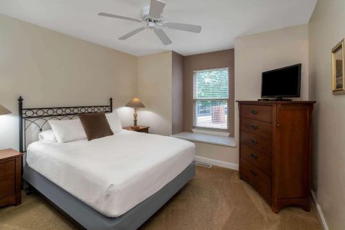 um quarto com uma cama e uma televisão de ecrã plano em Los Lagos at Hot Springs Village a Ramada by Wyndham em Hot Springs Village