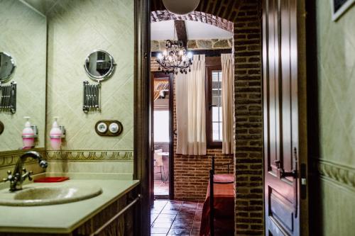 uma casa de banho com um lavatório e um espelho em Hotel Rural Finca La Herencia em Guadalcanal