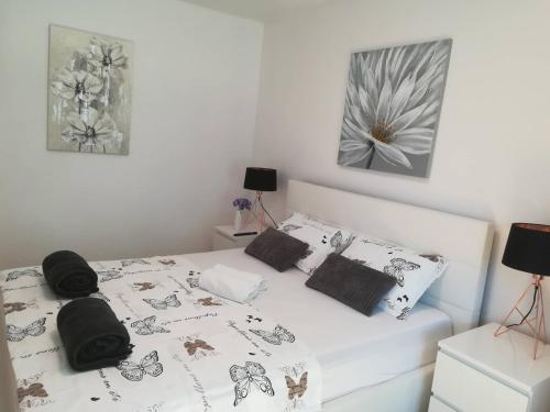a bedroom with a white bed with black and white pillows at APARTMAN D&D*** in Varaždin