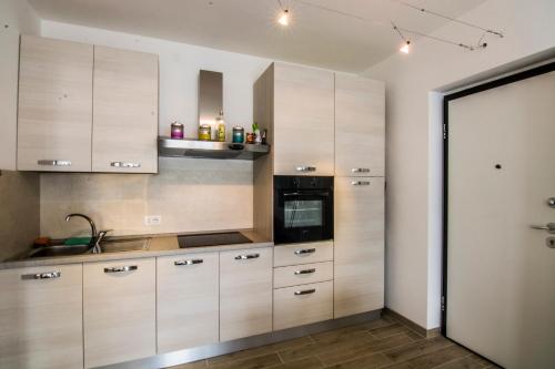 a kitchen with wooden cabinets and a sink at Residence Il Poggio in Dorio