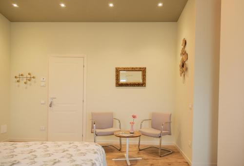 a bedroom with two chairs and a table and a bed at B&B Casa Pralunghi in Calvene