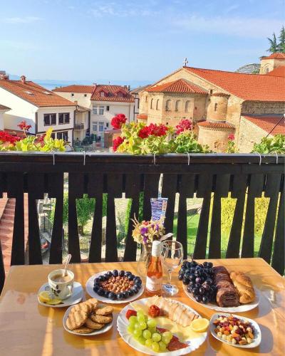 a table with plates of food on a balcony at Jovanovic Guest House in Ohrid