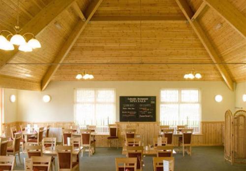 a classroom with desks and a chalkboard in a building at Lakes and woodlands Overstone Holiday Park in Northampton