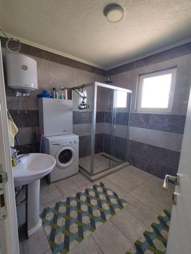 a bathroom with a sink and a washing machine at Air&Wiz Apartments in Krževići