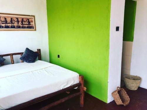 a bedroom with a green wall and a bed at Sonofjohnhomestay in Karatu