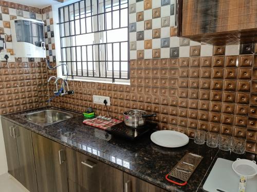 a kitchen with a sink and a counter top at New Metro Serviced Apartment in Chennai