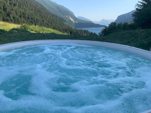 a hot tub with blue water in a mountain at Agriturismo Ai Castioni in Molveno