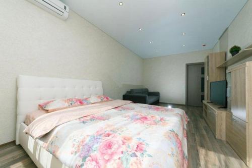 a bedroom with a large bed and a television at Видовая на 25 этаже in Kyiv