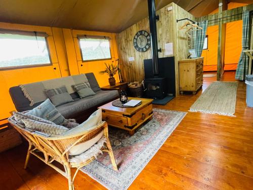 a living room with a couch and a table at Mountain View Safari Tent with Hot Tub in The Heart of Snowdonia in Dolgellau