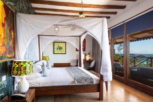 a bedroom with a canopy bed with a view of the ocean at Z Hotel in Nungwi