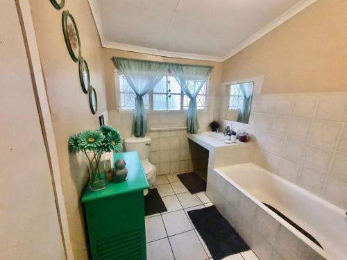 a bathroom with a tub and a toilet and a sink at 23 Ambleside Holiday Retreat by the sea in Port Shepstone