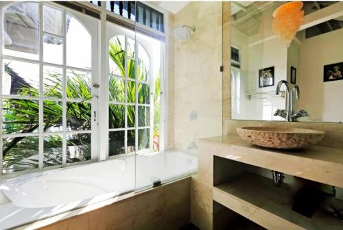 Blue Lagoon Apartment 3br في كوتا: حمام مع حوض ومغسلة ونافذة