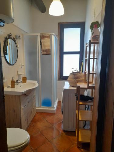a bathroom with a sink and a toilet and a window at La casetta di Tina in Marzamemi