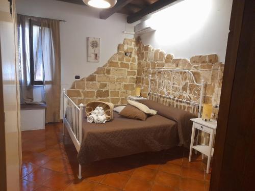 a bedroom with a bed with a stone wall at La casetta di Tina in Marzamemi