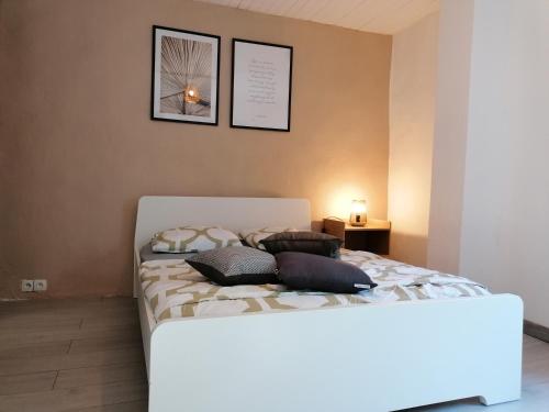 een slaapkamer met een bed met 2 kussens erop bij MAISON DE VILLAGE in Saint-Barthélemy-de-Vals