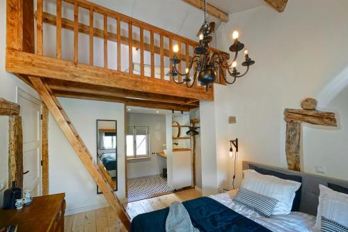 una camera da letto soppalcata con letto e scala di Vakantiehuis Dur Piepert a Eys
