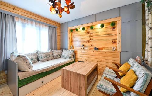 Cozy Home In Gornja Konjscina With Wifi في Hrašćina: غرفة بجدار خشبي مع مقاعد وطاولة