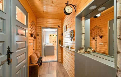 a hallway in a log cabin with a clock on the wall at Cozy Home In Gornja Konjscina With Wifi in Hrašćina