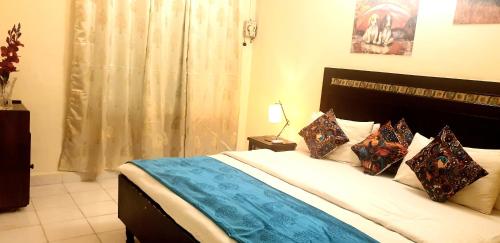 a bedroom with a large bed with pillows on it at CALANGUTE BEACH VILLA # 3BHk # POOL # KITCHEN # 300MTS TO BEACH by GR Stays in Calangute