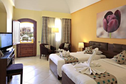 a hotel room with two beds and a television at Three Corners Rihana Resort El Gouna in Hurghada