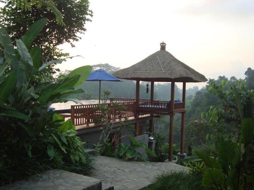 a gazebo with a table and an umbrella at Amori Villas in Ubud