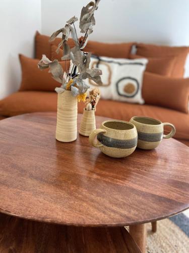 a wooden table with three vases on top of it at Suite La Farigoulette in Marseille