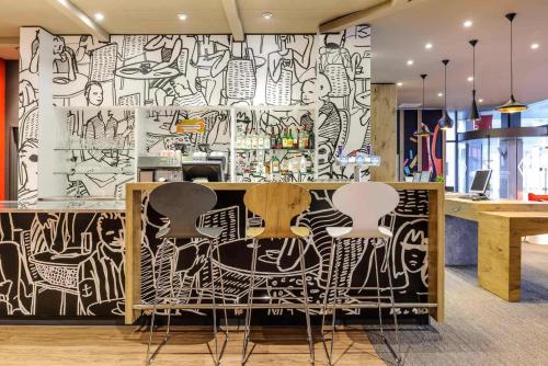 a restaurant with a wall covered in graffiti at ibis Baar Zug in Zug