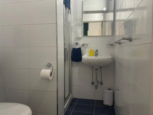 een witte badkamer met een wastafel en een toilet bij Parisio One Bedroom Maisonette in Sliema in Sliema