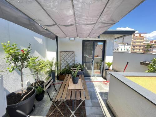 a balcony with a table and potted plants on it at Marranzanu Rooms in Santa Teresa di Riva