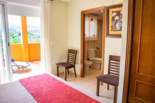 a bedroom with a bed and two chairs and a bathroom at Montemar Natura Resort in Peniscola