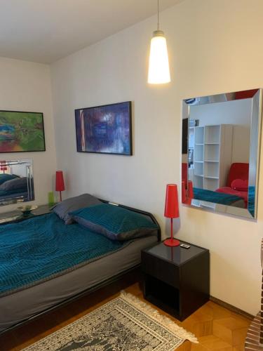 a bedroom with a bed and a mirror at CASA DOYA - Appartamento vintage in Muralto