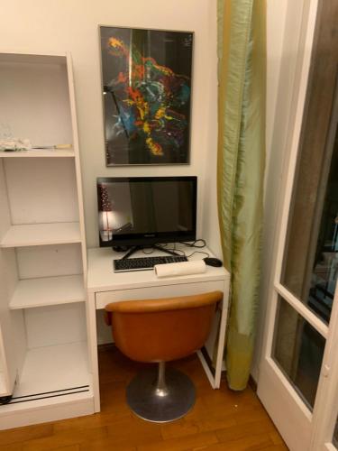 a desk with a computer monitor and a keyboard at CASA DOYA - Appartamento vintage in Muralto