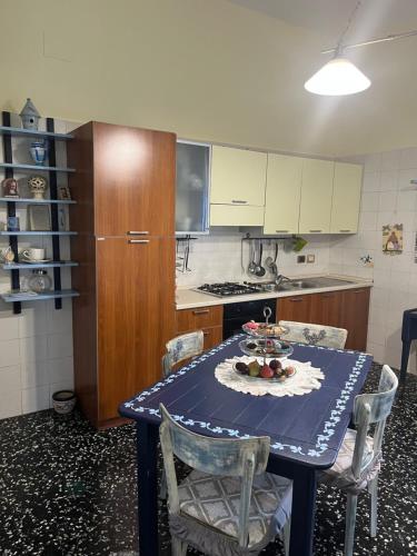 cocina con mesa y mantel azul en B&B Fabiola, en Pompeya